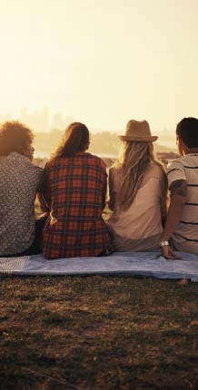 Group of friends sitting on blanket at a scenic overlook