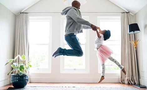 Father and daughter dancing in the living room