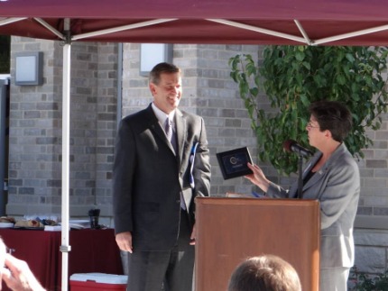 Woman handing man a plaque award