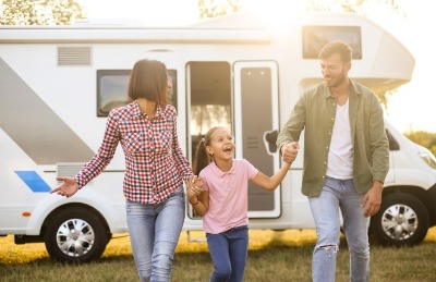 family of three happy in front of their r v