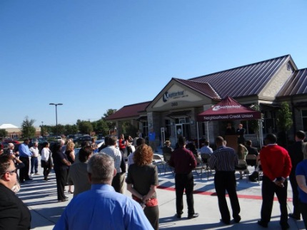 Crowd in front of building ribbon cutting