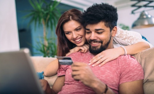 Man and woman at their laptop holding a credit card