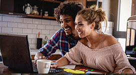 a couple sitting and looking at a computer together.