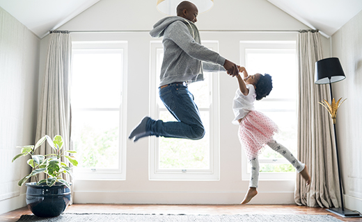 Father and daughter dancing in the living room