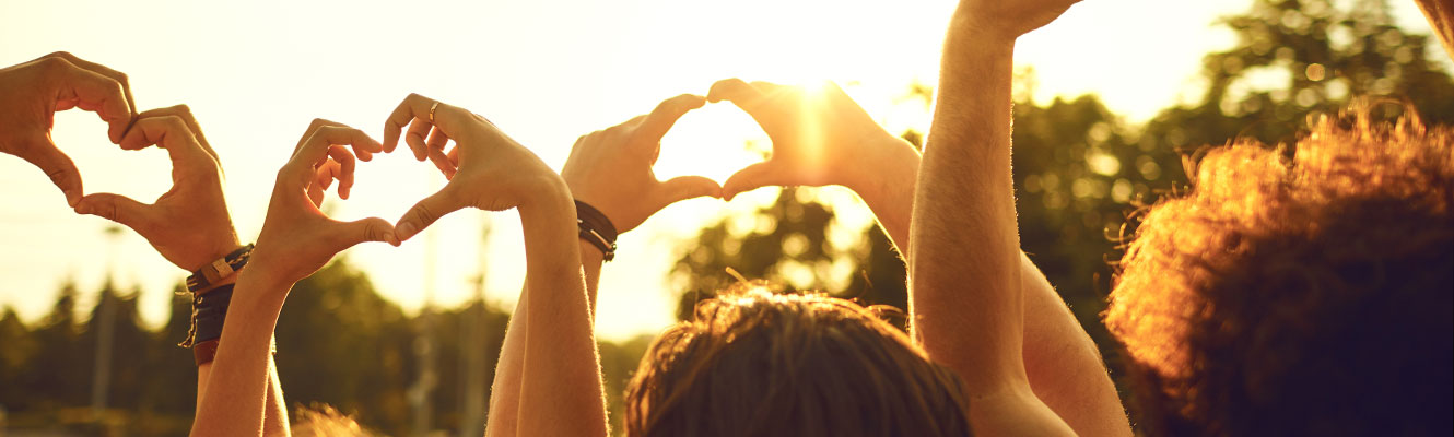 a group of people with their hands up in the air making hearts with hands. 