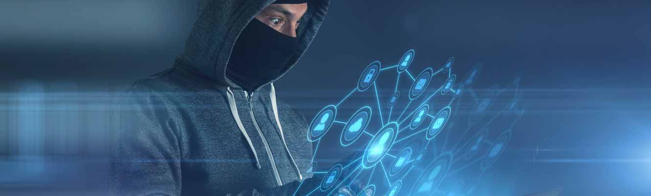 an edited image of a man with a hood on and ski mask covering his face looking at a tech device.