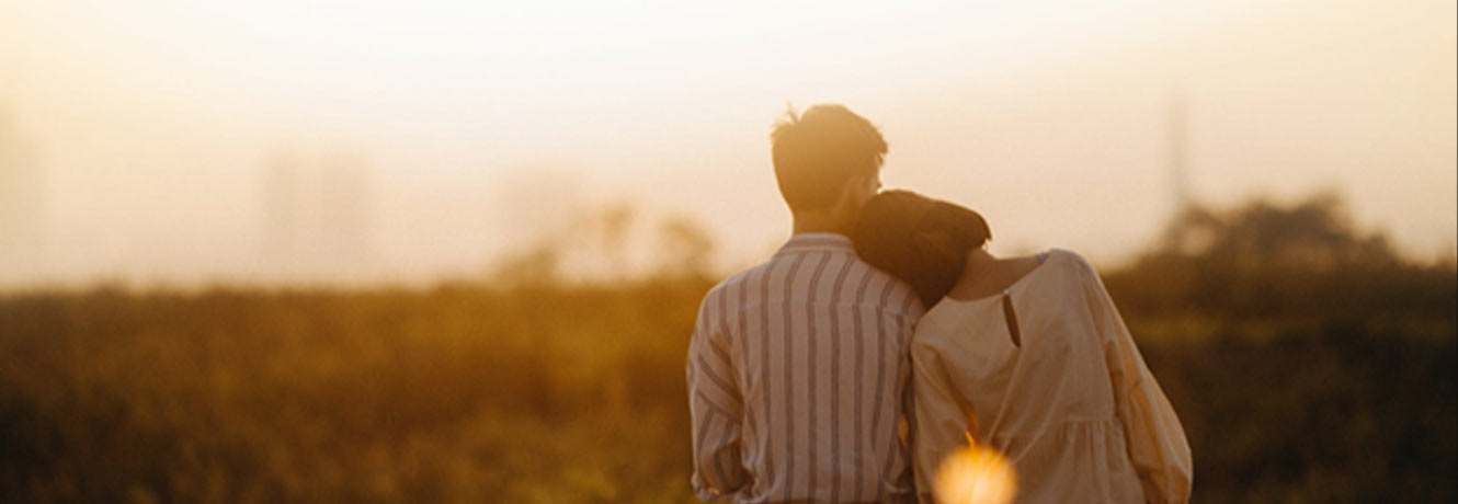 Sunset image with young couple looking off in the distance