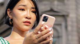Concerned woman looking down at her phone