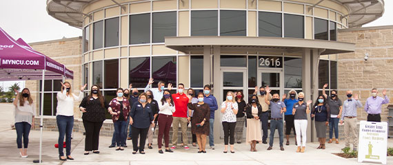 Still shot of Neighborhood Credit Union employees and Anna Chamber of Commerce members celebrating Anna branch grand opening.