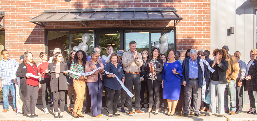 Still image of Neighborhood CU Employees and members, Local Mural Artist, and Oak Cliff representatives celebrating ribbon cutting.