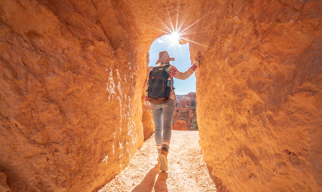 Person walking thru a natural rock arch