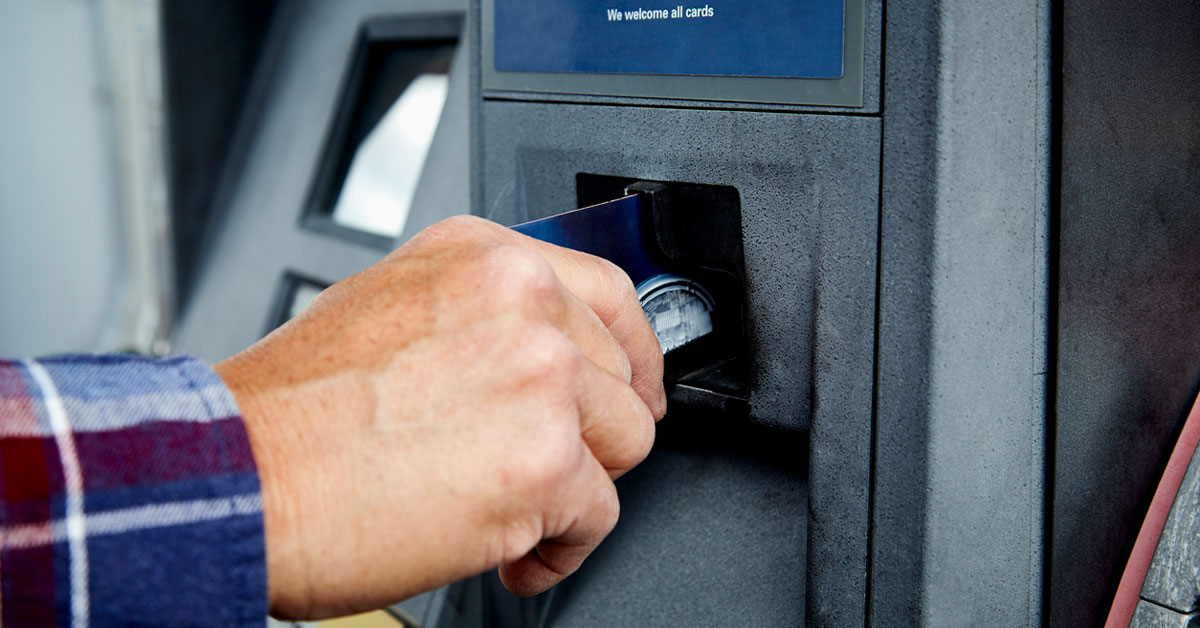 Man putting credit card in gas pump ATM to pay for gas at a gas station