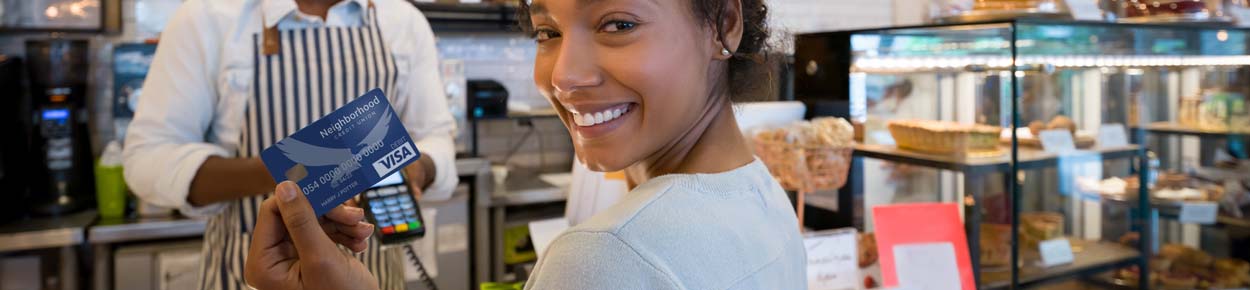 Woman using debit card to purchase at coffee shop