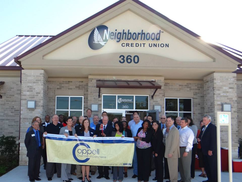 Building grand opening ribbon people holding banner