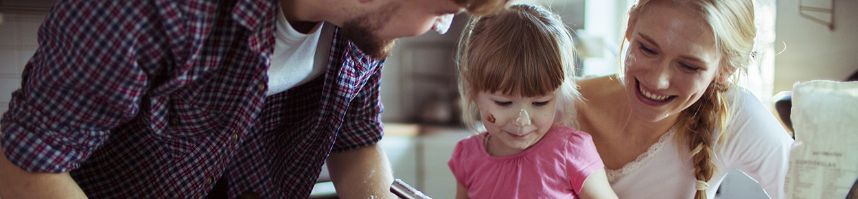 Mom, dad, and daughter banking in the kitchen