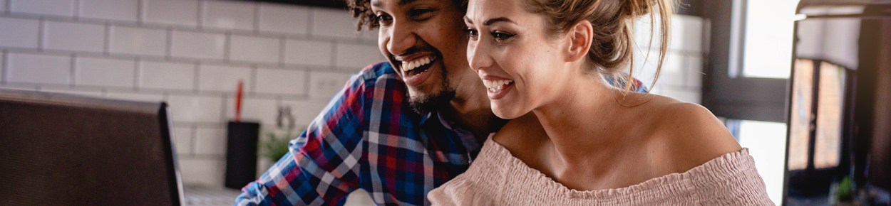 man and woman looking at a computer  smiling