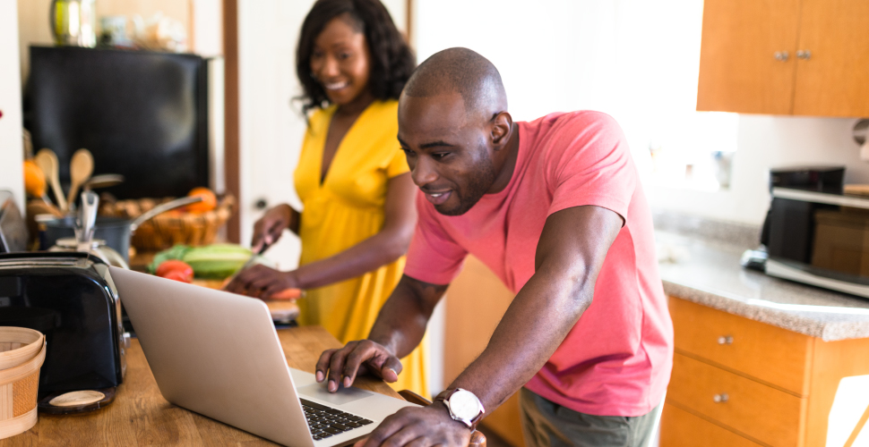 Young couple using laptop in kitchen