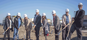 Group of people with hard hats breaking ground on new credit union location