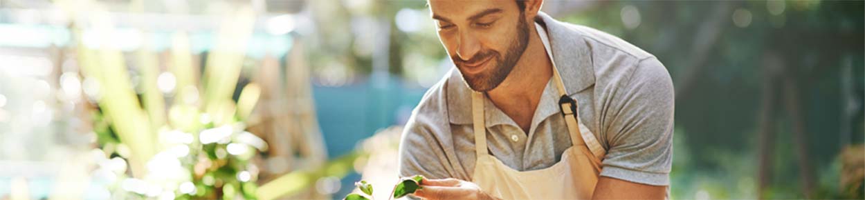 Man taking care of plants in a nursery