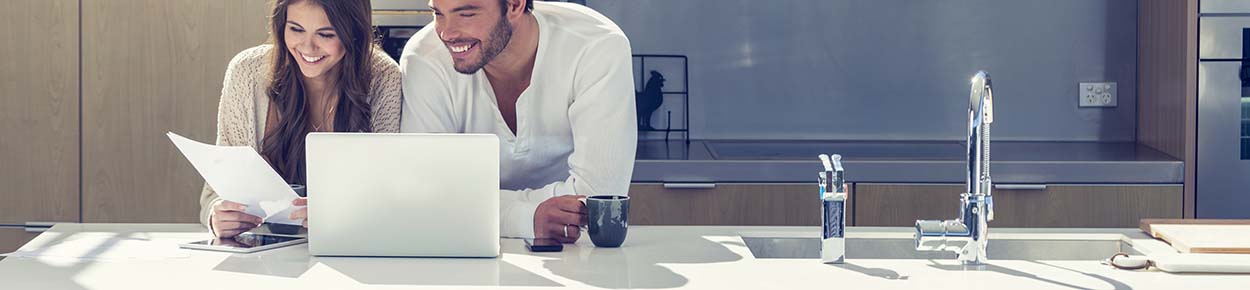 Couple at laptop in their kitchen