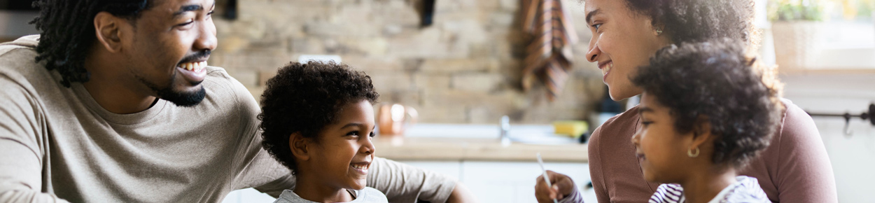 Father, mother, and two children spend time together in the kitchen