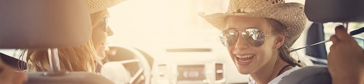 Two friends in cowboy hats in front seat of car