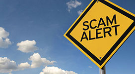Still image of a yellow road sign with the words "Scam Alert"