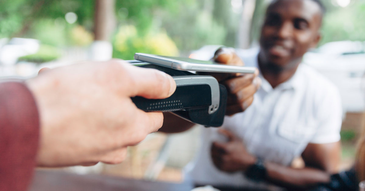 Close up of man making contactless payment in a cafe