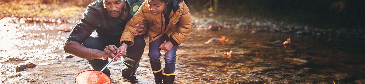 Father and son playing in a stream