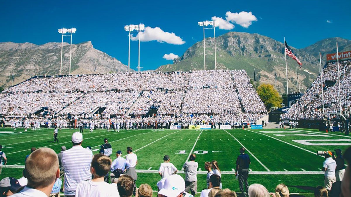 Football game on sunny day with crowd in stands