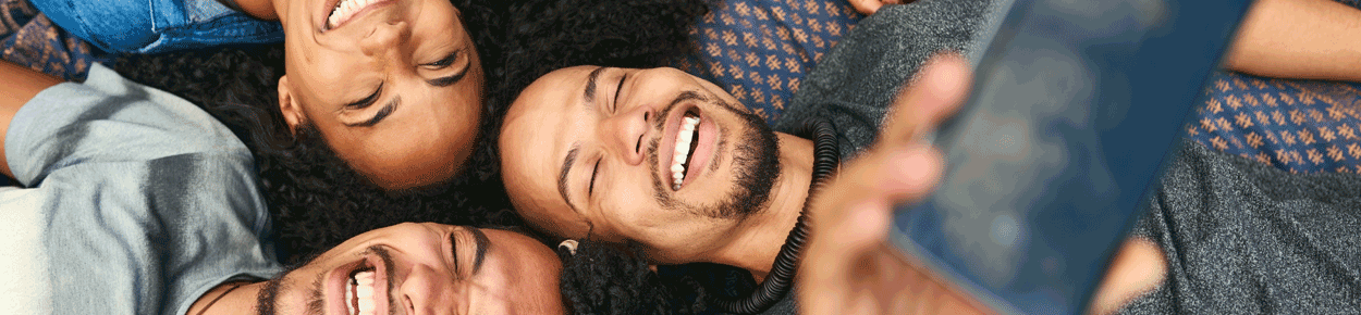 Friends lying down taking a group selfie