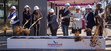 Group of Oak Cliff councilmen and Neighborhood Credit Union reps tossing dirt in the air at the oak cliff groundbreaking celebration.