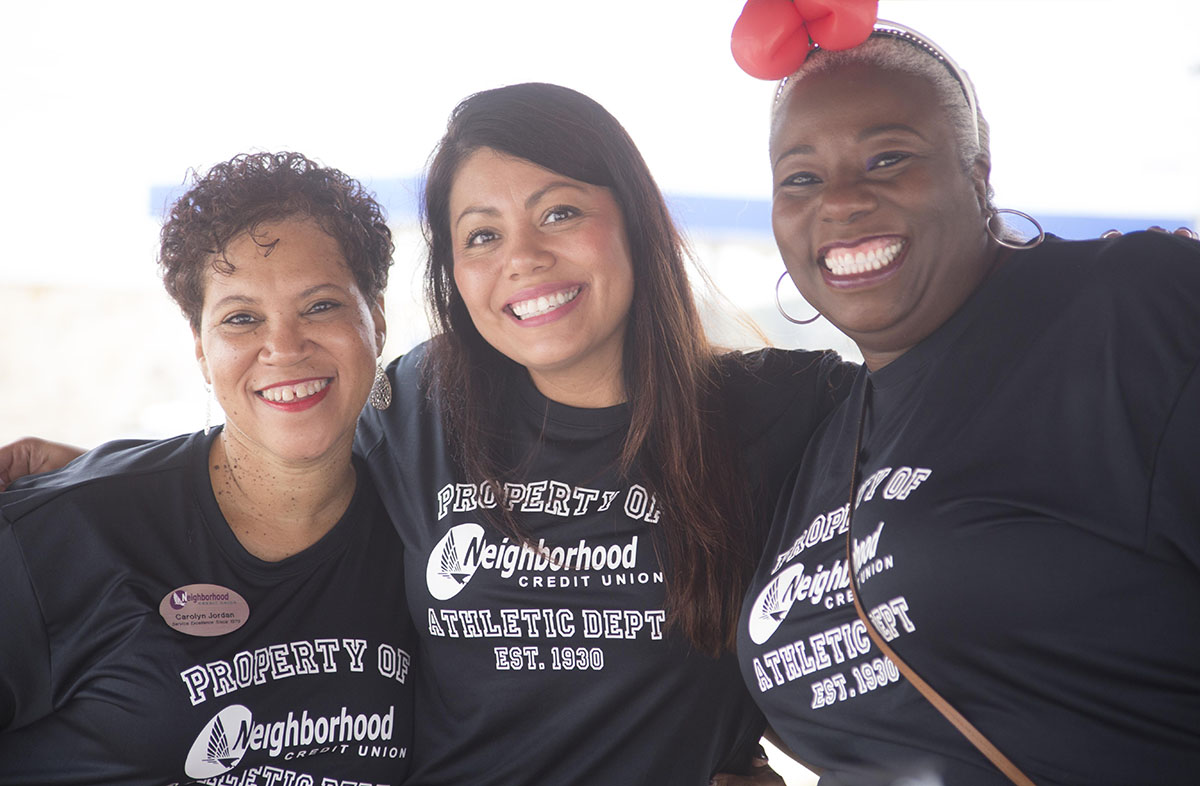 Three women smiling with arms around each other