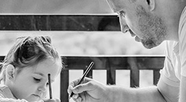 Father helping daughter with paper
