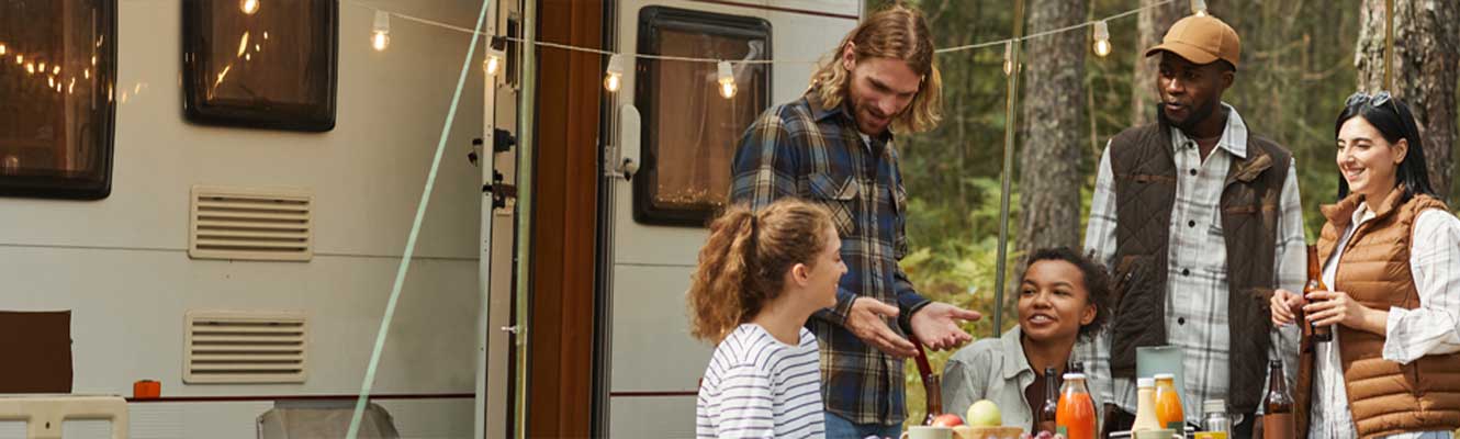 a multicultural group of people mingling at a RV camp site. 