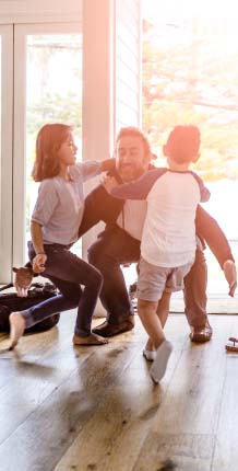 Father hugging children in doorway