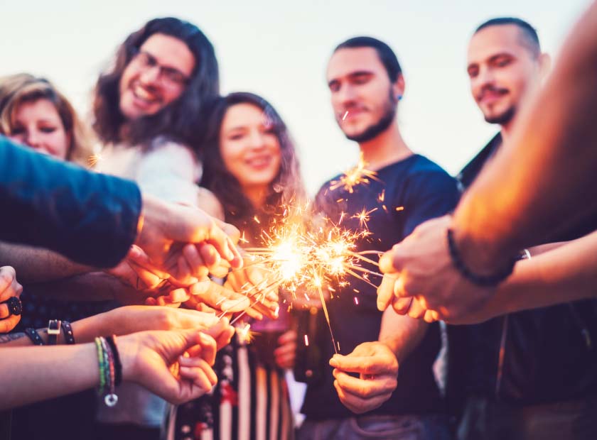 Group of friends holding sparkler fireworks