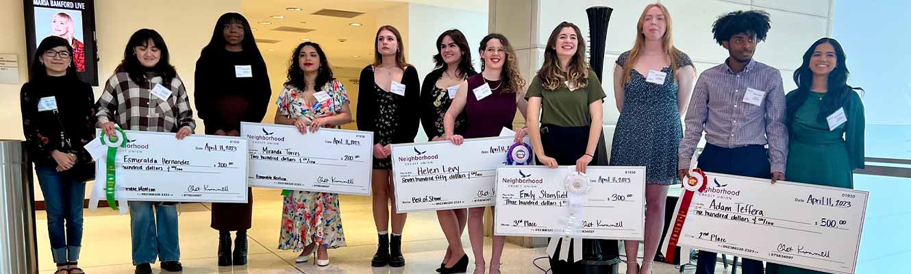 a group of Emerging Artists with the 5 winners holding oversized checks 