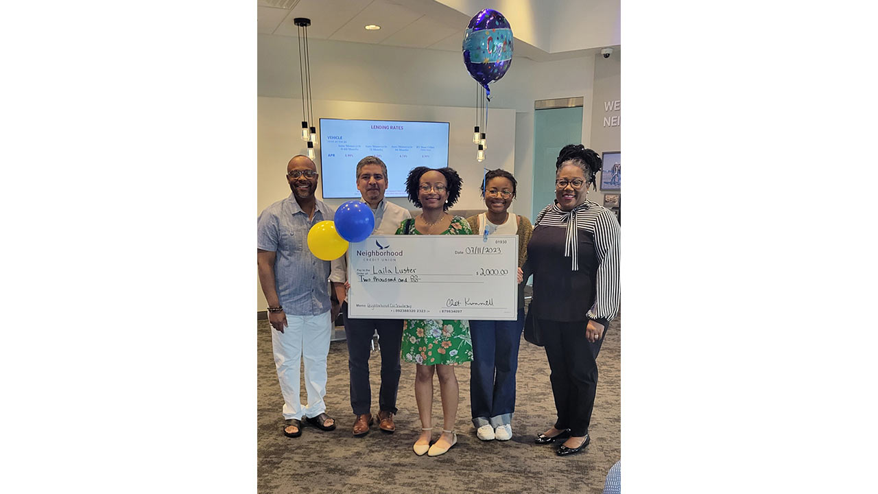 Five people holding up the 2023 scholarship oversized check. 