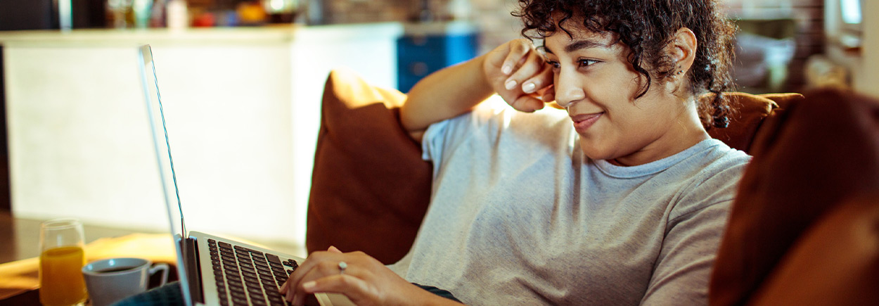 Close up of a young woman using a laptop at home