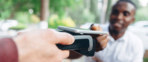 Close up of man making contactless payment in a cafe