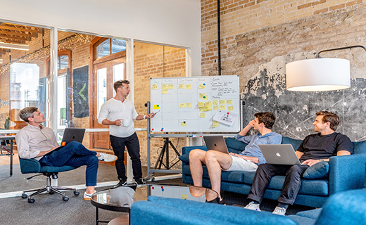 Group of people sitting around a white board