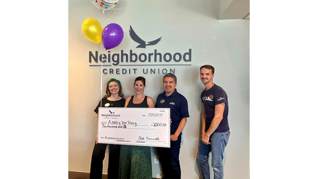 Four people holding up the 2023 scholarship oversized check. 