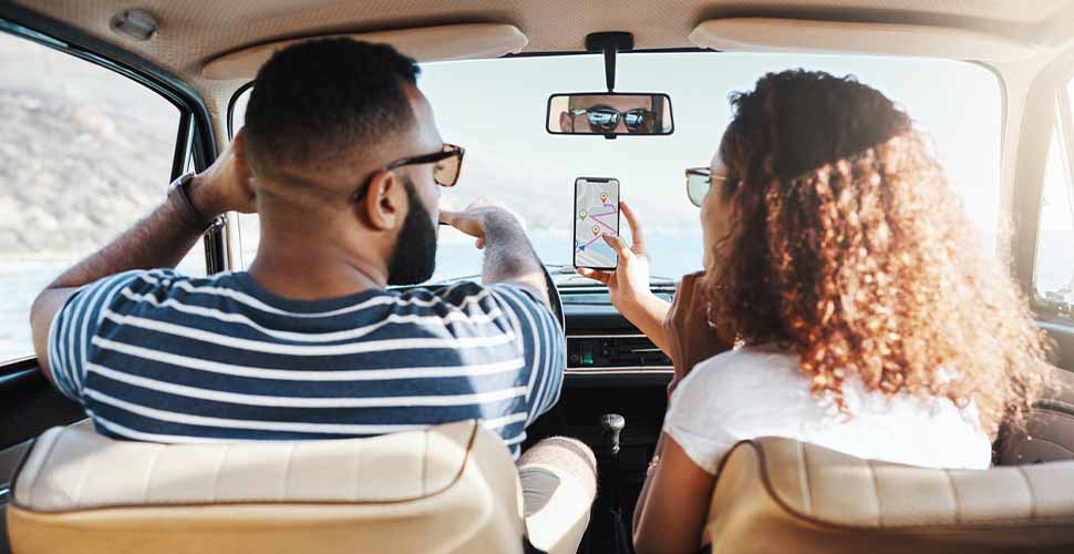 Shot of a young couple using gps on their mobile phone during a road trip